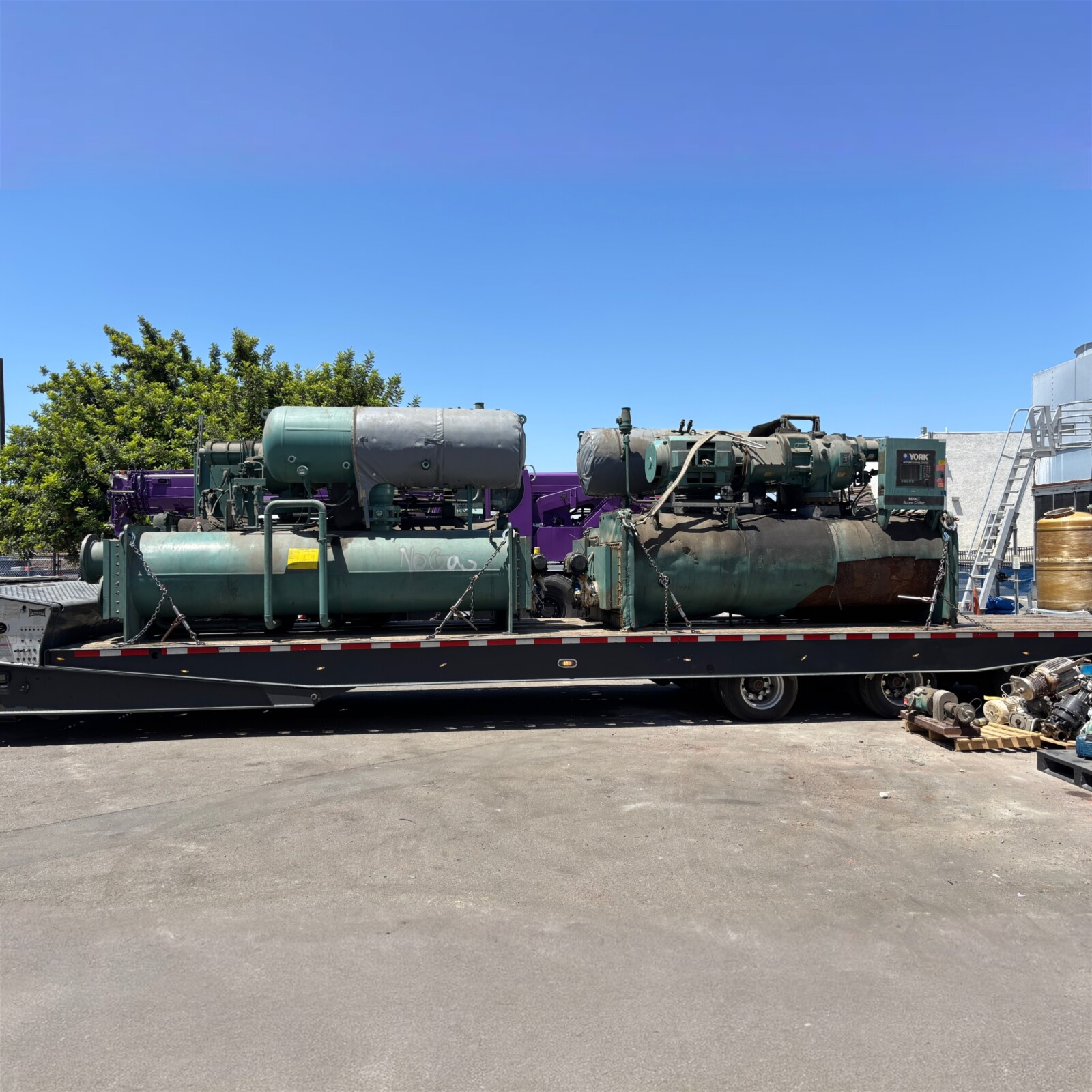 Multiple water-cooled chillers loaded for transport after plant removal